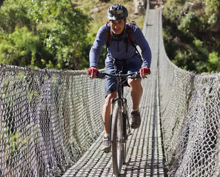 Ciclista cruzando puente en Bicicletas de montaña doble suspensión